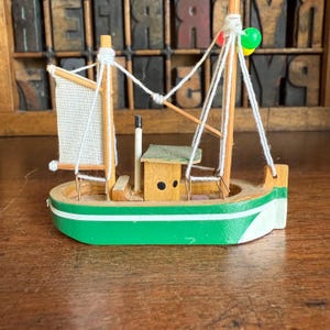 Miniature vintage green and white wooden fishing boat, ship. Nautical decor