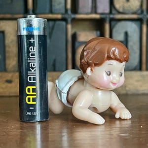Vintage miniature crawling baby doll wearing a nappy