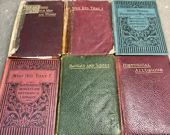 Peut inclure: Une collection de sept petits livres reliés vintage avec des couvertures marrons, vertes et bleues. Les livres sont intitulés "Who Did That?", "Battles and Sieges", "Historical Allusions", "Who Did That?", "5000 Words Frequently Mis-Spelt", "Famous Men and Women", et "Who Did That?"  Les livres font partie d'une série appelée "Routledge's Miniature Reference Library".