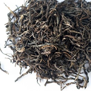 May include: Loose leaf black tea with long, thin, dark brown leaves.