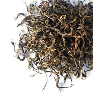 May include: Loose leaf black tea with long, thin, twisted leaves. The tea is a dark brown color with some lighter brown and green hues.
