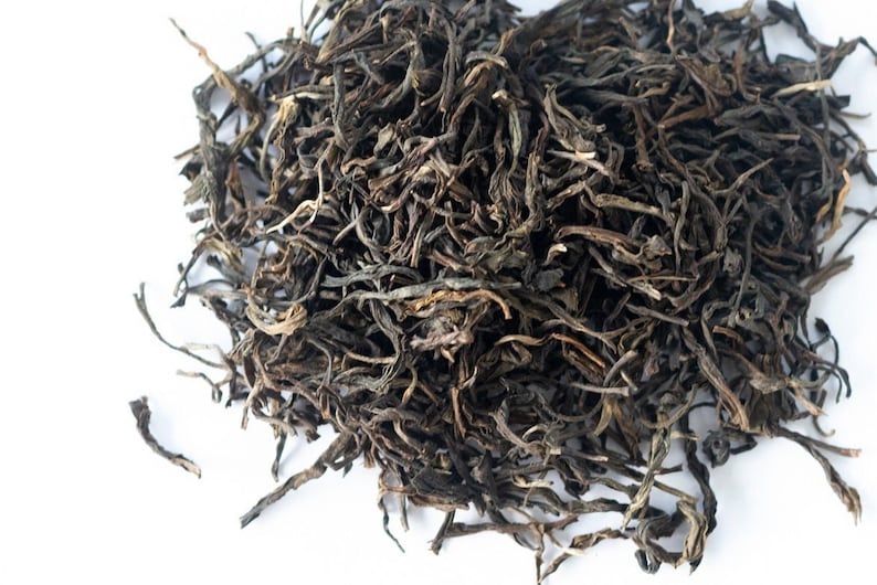 May include: Loose leaf black tea with long, thin, dark brown leaves.