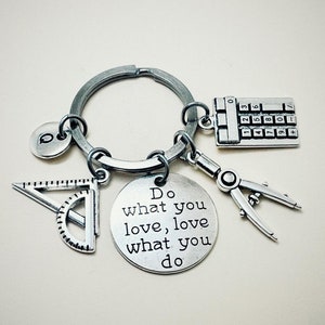 Può includere: Portachiavi color argento con ciondoli tra cui una calcolatrice, un goniometro, un compasso e un ciondolo circolare con la scritta "Do what you love, love what you do". Il portachiavi ha anche un ciondolo con la lettera "Q".