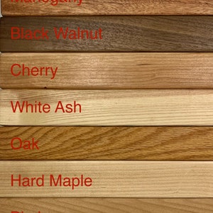 May include: Close-up of seven different wood samples, labeled with their names: Mahogany, Black Walnut, Cherry, White Ash, Oak, Hard Maple, and Birch.