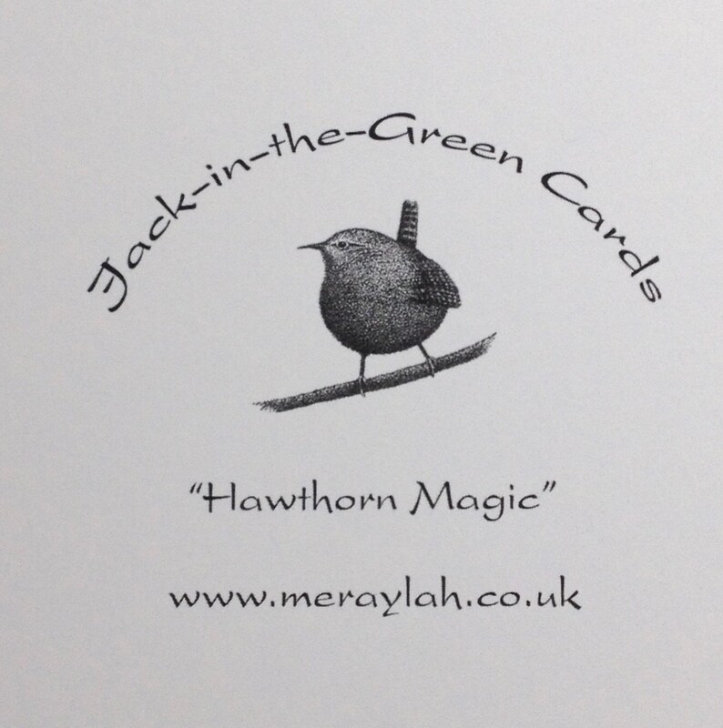 May include: Black and white illustration of a wren perched on a branch. The text "Jack-in-the-Green Cards" is written in a circular arc above the bird. The text "Hawthorn Magic" is below the bird. The text "www.meraylah.co.uk" is below the text "Hawthorn Magic".