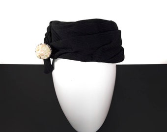 Black pillbox hat, with large iridiscent ivory ornaments, 1950s vintage. Black ribbed knit hat, women's