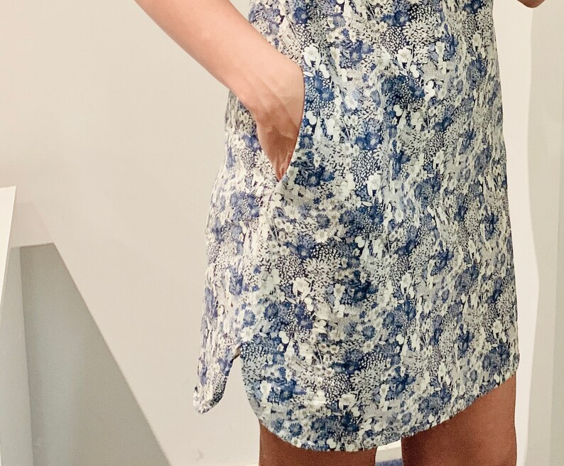 Puede incluir: Un vestido corto de flores azul y blanco con un bolsillo en el lateral.