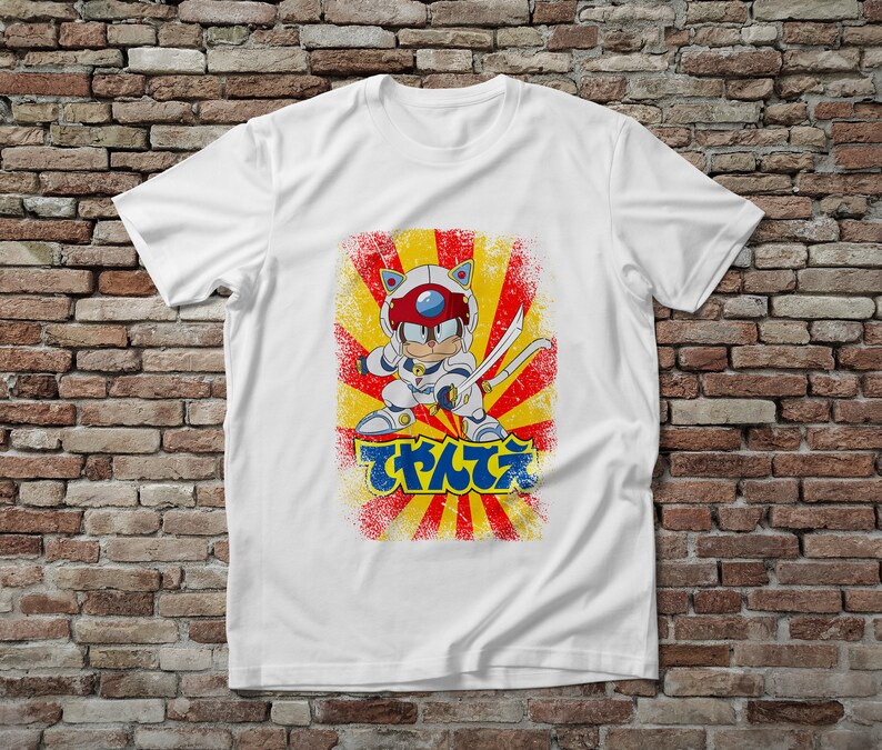 Puede incluir: Camiseta blanca con un personaje de dibujos animados con un traje futurista, sosteniendo una espada. El dise&ntilde;o incluye un fondo de rayos de sol rojo y amarillo y texto japon&eacute;s. El personaje tiene rasgos de gato y lleva un casco.