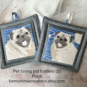 May include: Two square pot holders with a pug design. The pug is light beige with a black muzzle and floppy ears, set against a blue and white striped background. The pot holders are framed in gray fabric and have a loop for hanging. Text on the image reads: Pet loving pot holders (2) Pugs furmommacreations.etsy.com