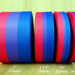 Może przedstawiać: Cztery rolki wstążki w czerwono-niebieskie paski o różnych szerokościach: 7,6 cm (75 mm), 3,8 cm (38 mm), 2,2 cm (22 mm) i 0,9 cm (9 mm).