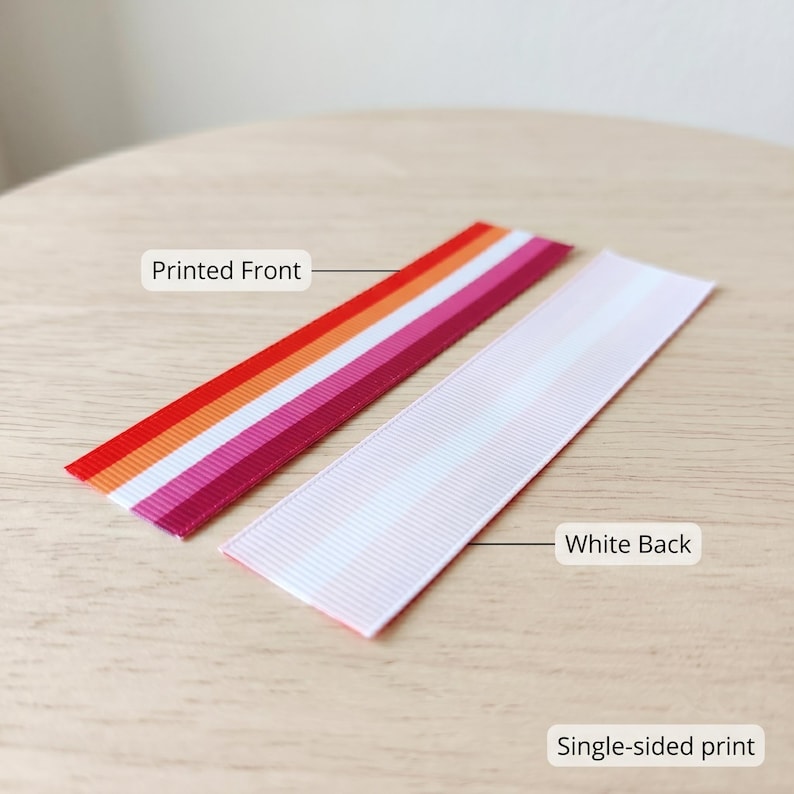 Peut inclure: Deux rubans, l'un avec un recto imprim&eacute; &agrave; rayures rouges, oranges, blanches et roses, et l'autre avec un verso blanc. Les textes "Printed Front", "White Back" et "Single-sided print" sont visibles.