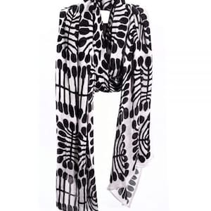 May include: A black and white patterned scarf with a geometric design. The scarf is made of a soft, lightweight fabric and is perfect for adding a touch of style to any outfit.