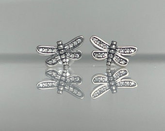 May include: A pair of silver dragonfly earrings with clear crystal accents.