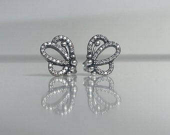 May include: A pair of silver butterfly earrings with clear cubic zirconia stones.