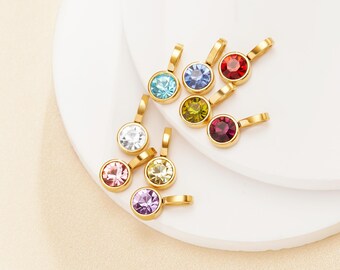 May include: Assortment of small, round, gold-toned pendants with colorful crystal accents. The pendants feature a variety of colors, including red, blue, green, yellow, pink, and purple.