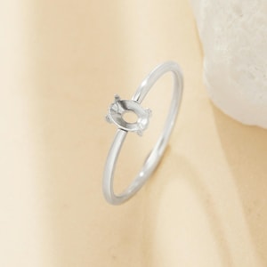 Op de afbeelding: Een zilveren ring met een ovale zetting voor een edelsteen. De ring is simpel en elegant, perfect voor een minimalistische look.