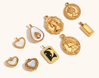 May include: A collection of gold-colored pendants in various shapes, including hearts, an avocado, and rectangular and oval designs. Some pendants feature mother-of-pearl inlays or relief portraits. One pendant has a black background with a crescent moon and stars.