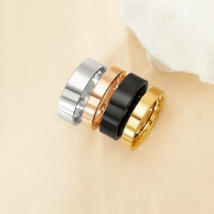 May include: Four stackable rings in silver, rose gold, black, and gold.