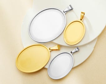 May include: Four oval-shaped metal pendant blanks with a shiny finish. Two are silver and two are gold. The pendants are arranged on a white surface.