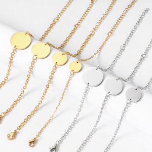 Peut inclure: Colliers dorés et argentés avec un pendentif circulaire. Les colliers présentent une chaîne délicate et un pendentif rond et plat. Les colliers dorés ont un fermoir mousqueton, tandis que les colliers argentés ont un fermoir similaire.