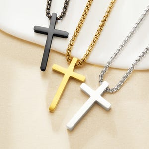 Può includere: Tre collane con croci nere, dorate e argentate. Ogni ciondolo a forma di croce è sospeso a una catena abbinata. Le croci hanno un design semplice e una finitura liscia e lucida.