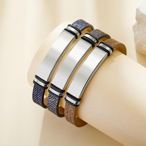 May include: Three leather bracelets with silver metal plates. The bracelets are in blue, brown, and black.