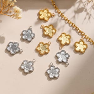 May include: Assortment of gold and silver flower-shaped charms with a hole for attaching to jewellery. The charms have a delicate, detailed design.