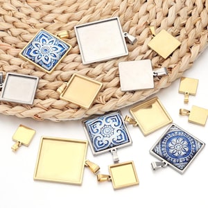 Peut inclure: Assortiment de plateaux de pendentifs carrés dorés et argentés avec une variété de carreaux de verre à motifs bleus et blancs. Les plateaux sont parfaits pour créer des bijoux personnalisés.