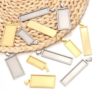 Può includere: Una collezione di vassoi rettangolari per ciondoli in oro e argento con una finitura liscia e lucida. I vassoi sono perfetti per creare pezzi di gioielleria personalizzati.