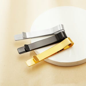 May include: Three metal money clips in gold, silver and black.