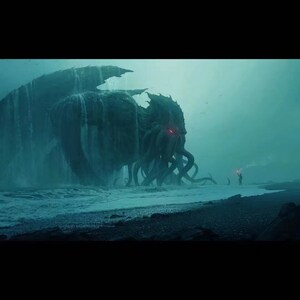 May include: A large, green, tentacled creature with glowing red eyes emerges from the ocean, standing on a black sand beach. A small figure with a torch stands on the shore, looking up at the creature.