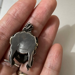 May include: Silver pendant with a detailed design, featuring the text "HAGER 2021" and the number "925" on the back.