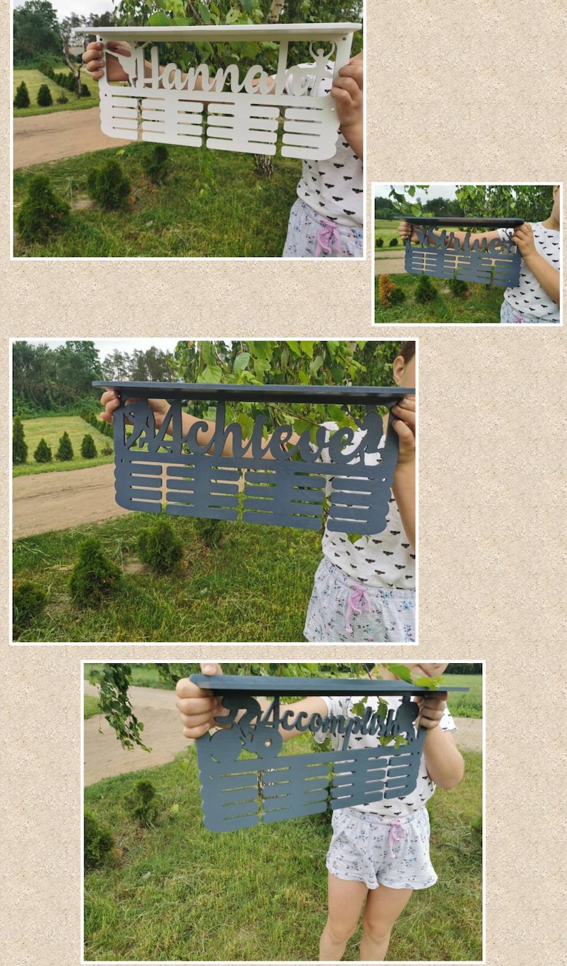 May include: A white wooden medal display with the name "Hannah" and a silhouette of a dancer. The display has 20 slots for medals.