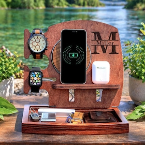 May include: A wooden charging station with a watch, smartwatch, phone, and wireless earbuds. The phone shows a charging symbol. The station has a tray for small items and is engraved with the name "Miller".