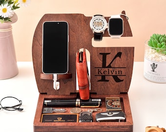 May include: A wooden organizer with a personalized initial "K" and the name "Kelvin" engraved on it. The organizer has slots for a phone, watch, and other accessories. It also has a small tray for keys, wallet, and other items.