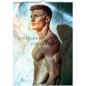 May include: A wall calendar for 2027 titled Les Hommes du Rugby calendrier 2027, featuring a portrait of a shirtless, muscular individual with short hair, captured in profile against a bright, ethereal blue and white light-filled background.