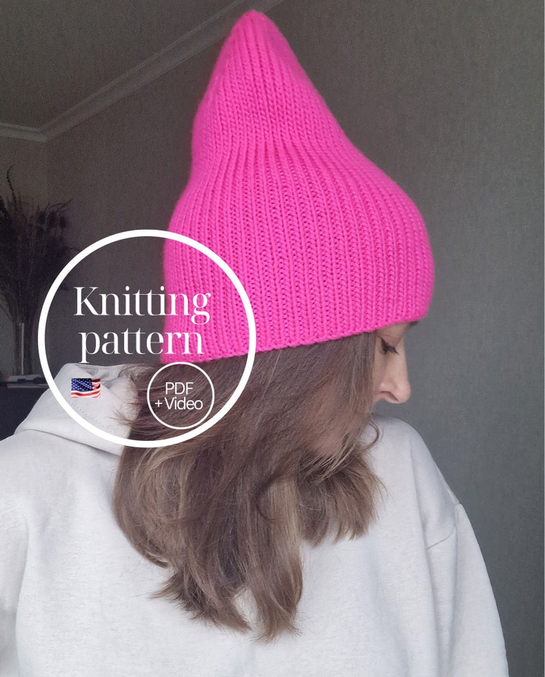 Op de afbeelding: Een felroze gebreide muts met een puntige top. De muts is gemaakt van een geribbelde gebreide stof. De afbeelding bevat de tekst "Knitting pattern" en "PDF + Video".
