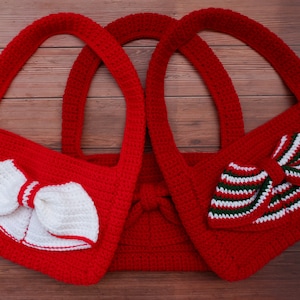 以下が含まれることがあります： 異なる色のリボンが付いた赤い編み物のバッグが3つ。バッグはストラップが1つで、質感のある糸で編まれています。