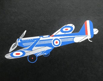 Avión de hélice de 1934. Serigrafía impresa en cartulina negra Apsley Mills 'Dignity'. Tamaño de la imagen: aprox. 5,5 x 3 pulgadas. Borde con tinta plateada. Insignias de la RAF.
