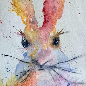 May include: Watercolor painting of a rabbit's face with large eyes and long whiskers. The rabbit's fur is a blend of red, orange, yellow, and blue hues. The artwork has a whimsical and expressive style, with visible brushstrokes.