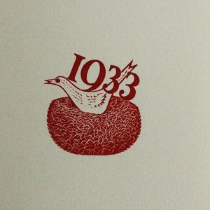 May include: A red and white illustration featuring a bird in a nest with the number "1933" above it. The bird is white with black details, and the nest is a textured red. The background is a light beige color.