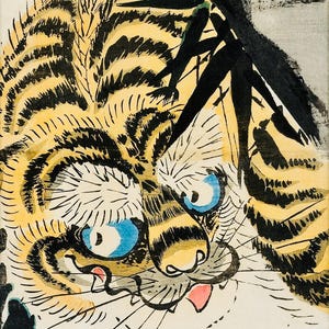 Puede incluir: Una detallada y colorida xilografía japonesa de un tigre. El tigre tiene rayas amarillas y negras, ojos azules y una lengua rosa. Tallos de bambú enmarcan la cara del tigre. El fondo es azul claro.
