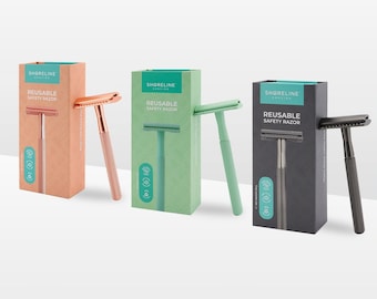 May include: Four boxes of reusable safety razors with different colored handles. The boxes are green, black, pink, and blue. The razors are all the same design, but the handles are different colors. The boxes have the text "Shoreline" and "Reusable Safety Razor" on them.