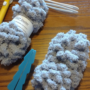 Peut inclure: Deux plumeaux en microfibre gris avec une étiquette blanche indiquant "360* Duster Washable and dryable together on handle when not in use".