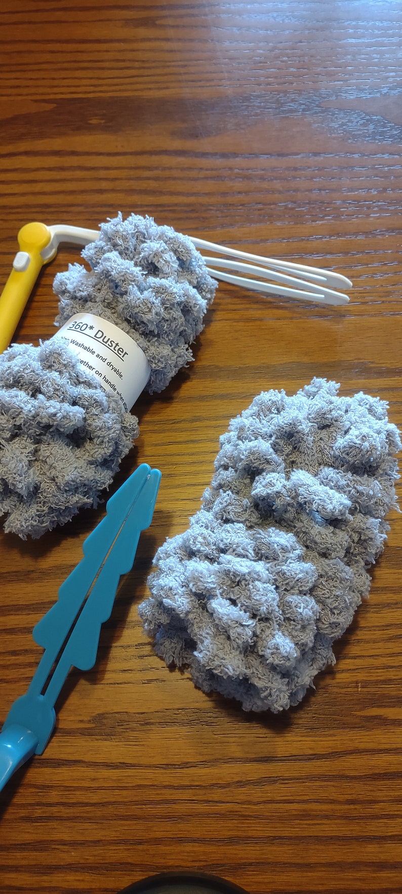 May include: Two gray microfiber dusters with a white label that reads "360* Duster Washable and dryable together on handle when not in use".