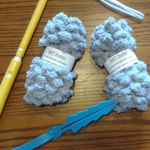 May include: Two gray microfiber dusters with the text "360* Duster Machine Washable and dryable. Squeeze prongs together on handle."  A yellow and white duster handle and a blue cleaning tool are also pictured.