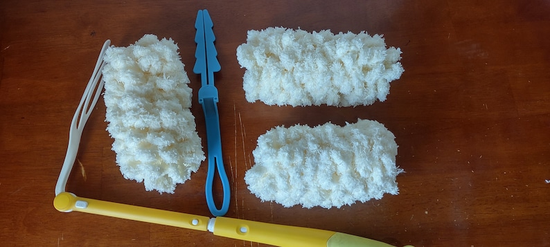 May include: A cleaning kit with a yellow and white extendable handle, a white plastic frame, and three fluffy, cream-colored cleaning pads. Also included is a blue plastic tool.