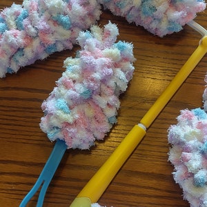 Pu&ograve; includere: Un set di cinque spolverini soffici e colorati con un manico giallo e blu. Gli spolverini sono realizzati in filato morbido e soffice in tonalit&agrave; di rosa, blu, bianco e viola.