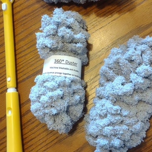 May include: Three gray microfiber dusters with yellow and blue handles. The dusters are labeled "360* Duster Machine Washable and dryable.  Squeeze prongs together on handle to use."