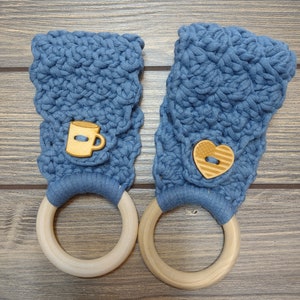 May include: Two blue crocheted dishcloths with wooden rings. One dishcloth has a brown button shaped like a coffee cup, the other has a brown button shaped like a heart.
